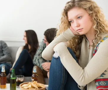 a young woman isolated from her a group of friends