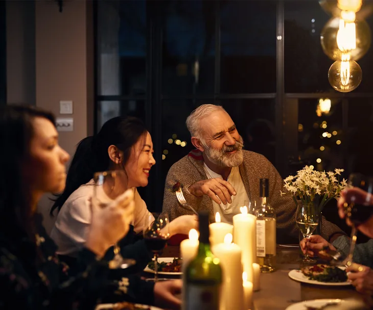 people of all ages round a table at dinner party