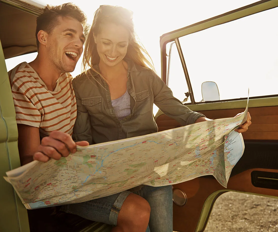 Couple sitting in truck consult map happily