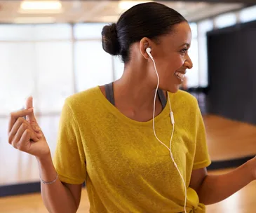 happy woman dancing listening to music on earphones