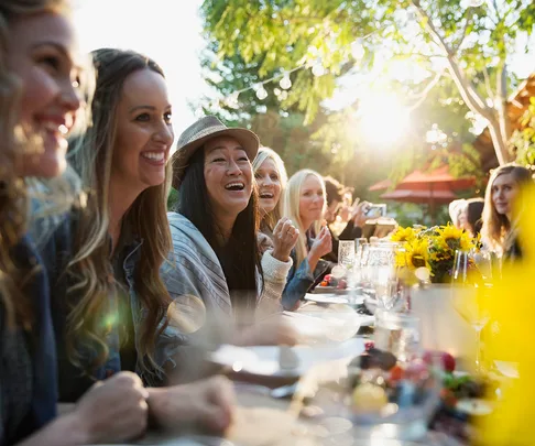 women laughing at a dinner party