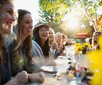 women laughing at a dinner party