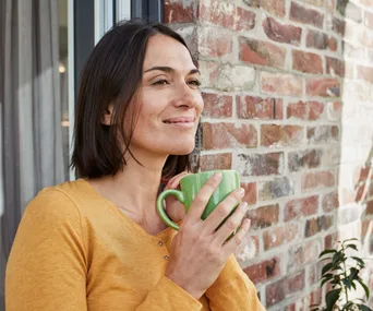brunette woman smiling drinking coffee