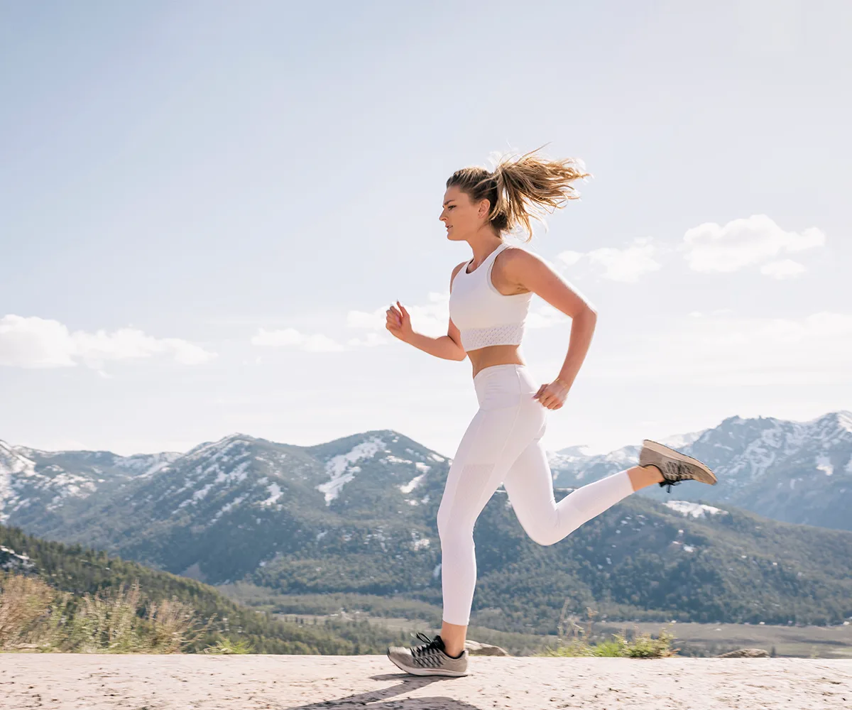 blonde woman running in the mountains