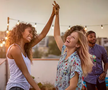 friends dancing on rooftop
