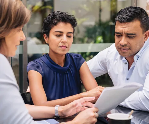 Woman explaining documents to a concerned couple