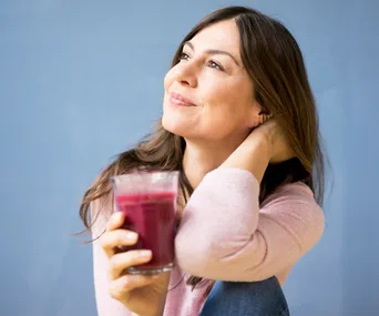 Smiling woman holding glass of juice