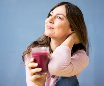 Smiling woman holding glass of juice