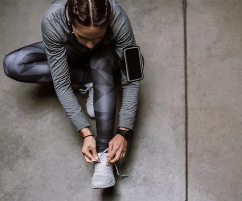 Runner stretching while tying shoe laces