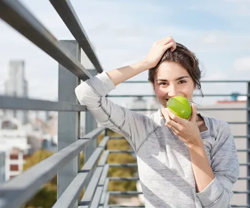 Young woman eating green apple