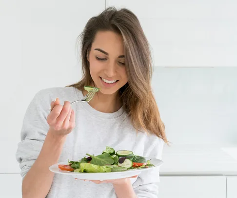 Brunette woman eating a salad