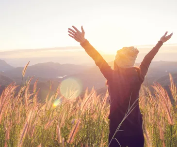 woman arms outstretched at sunrise