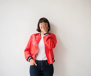 embarrassed woman with hands covering face