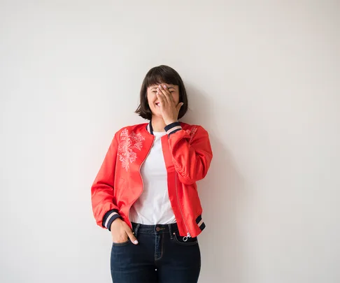 embarrassed woman with hands covering face