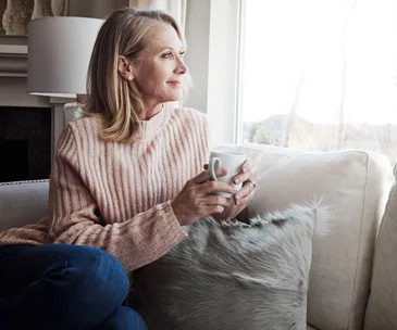 woman drinking tea looking out window