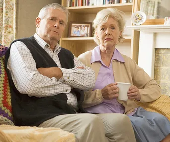 Unhappy couple sitting on sofa
