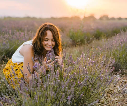 woman smelling lavender in field