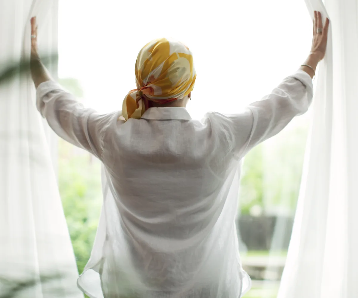 Woman wearing bandana opening curatins