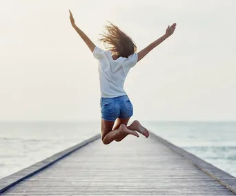 woman full of energy jumping on a pier