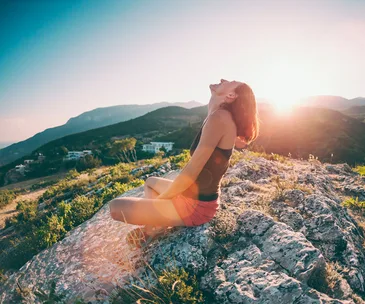 woman sitting on a mountain sun spot