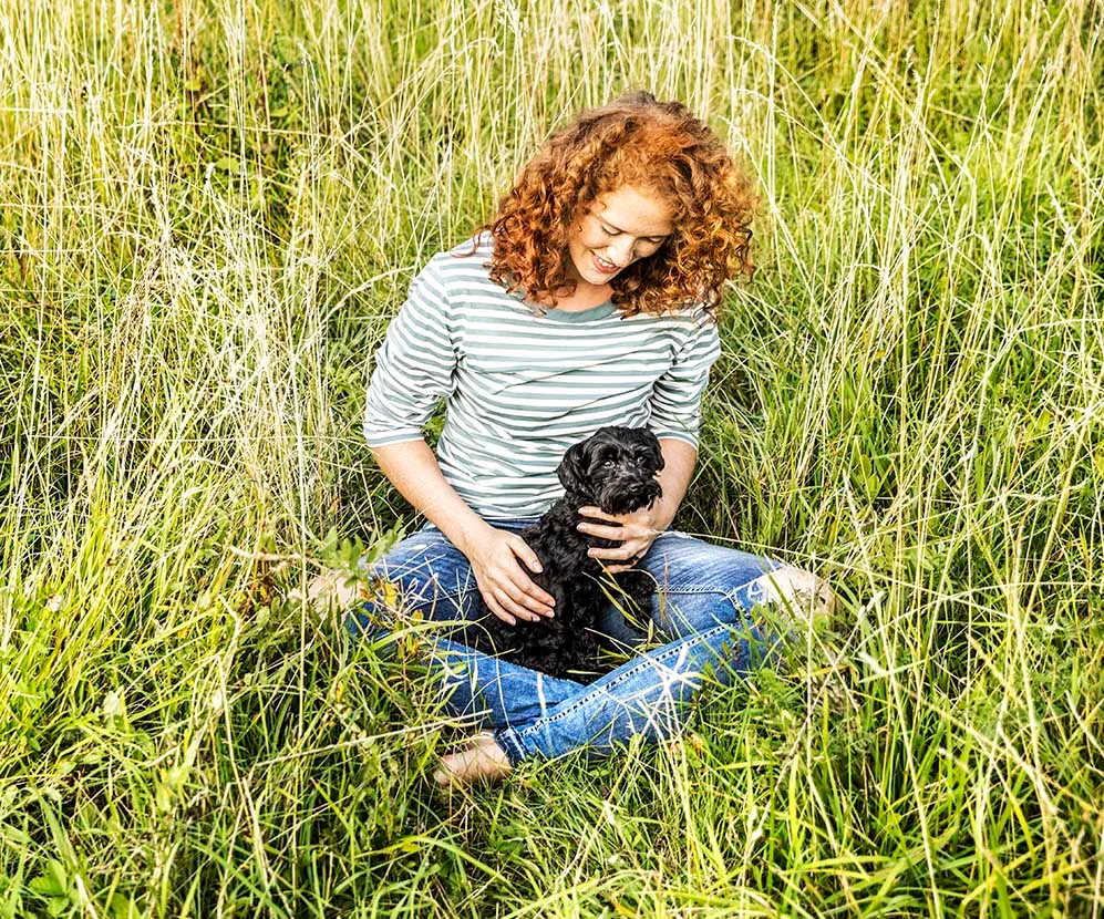 woman in a field with a dog