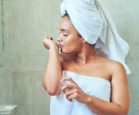 woman smelling wrist with perfume