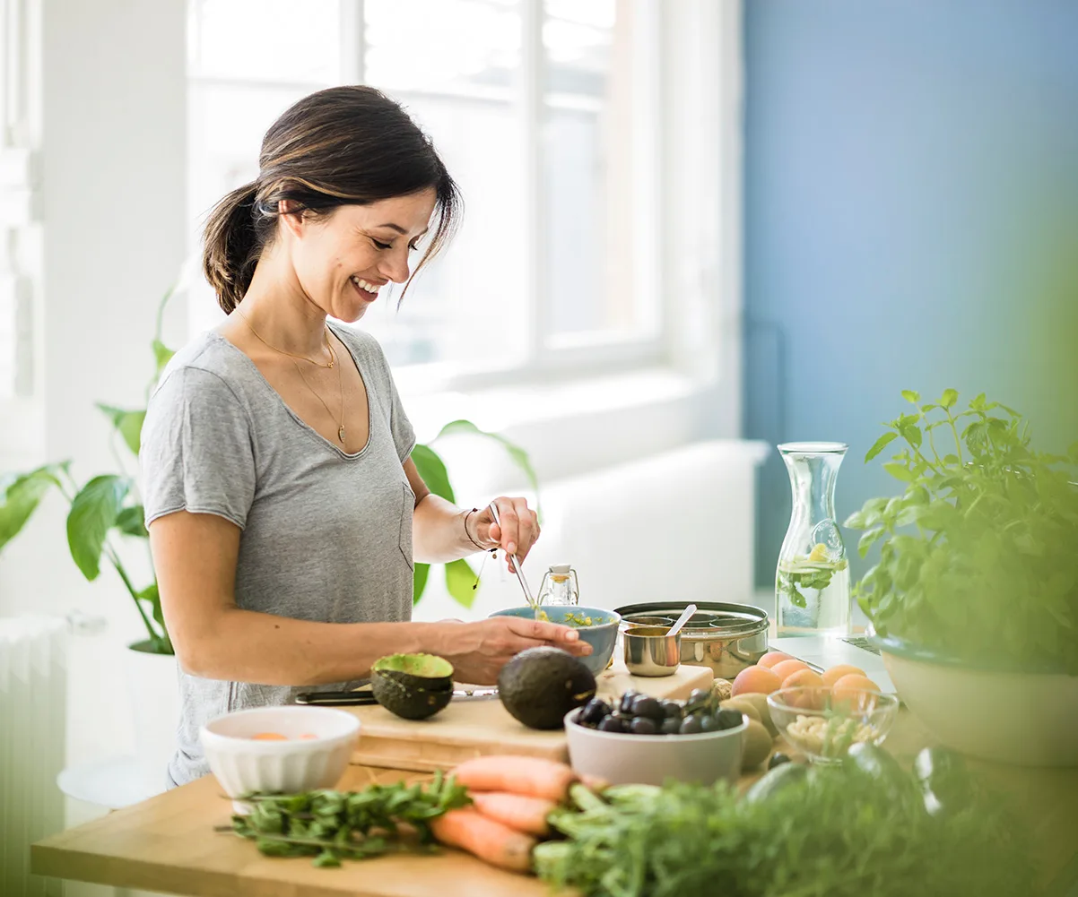 happy woman in the kitchen making guacamole