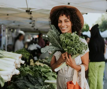 woman shopping for kale at farmer's market