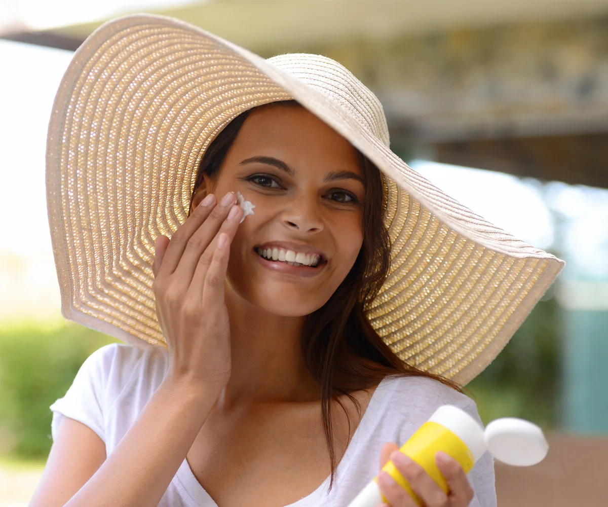Woman applying sunscreen to face