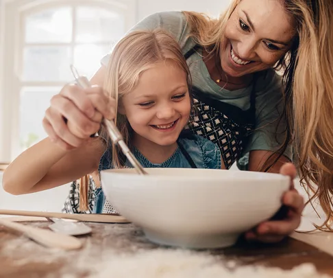 mother and daughter baking in kitchen