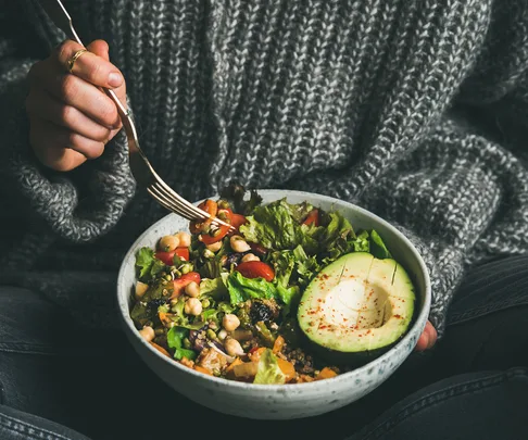 woman holding healthy buddha bowl salad