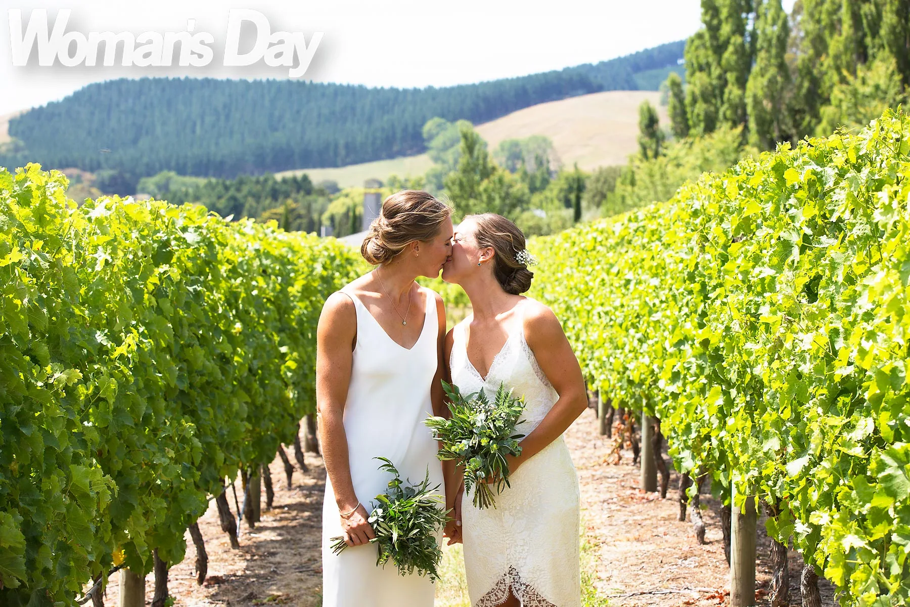 Emma Twigg and new wife Charlotte kissing in a vineyard on their wedding day
