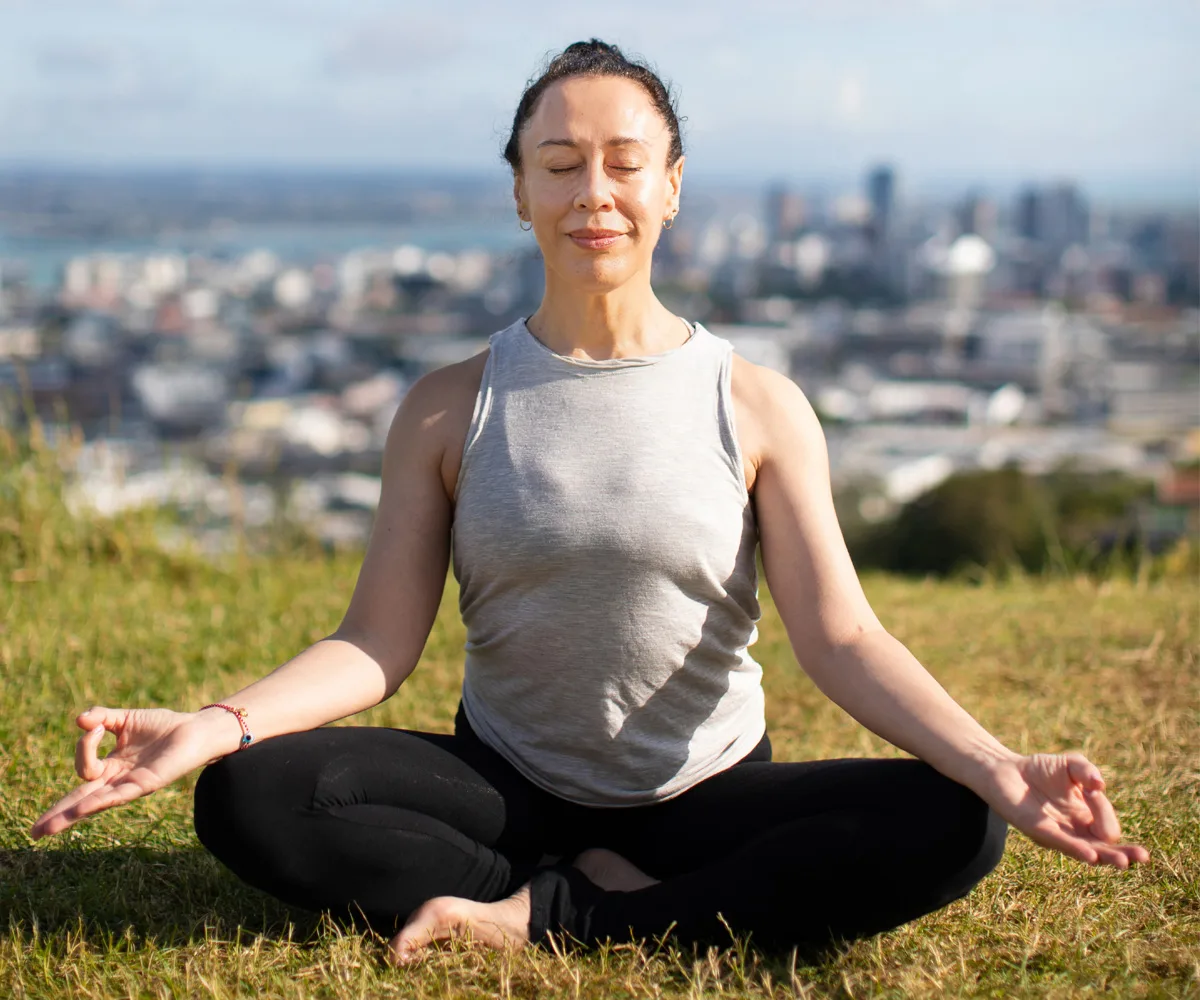 Woman doing yoga on top of Maungawhau Mt Eden