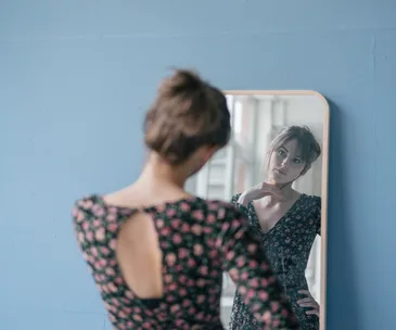 Indecisive woman looking in mirror
