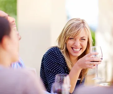woman smiling and drinking wine