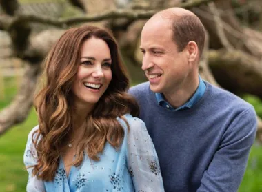 I don't know who they are, but the image shows a woman in a blue dress and a man in a blue sweater, smiling outdoors.