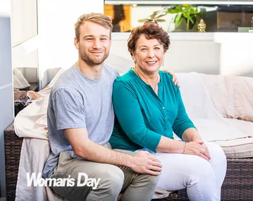 A young man and an older woman sitting on a sofa, smiling, with "Woman's Day" logo in the corner.