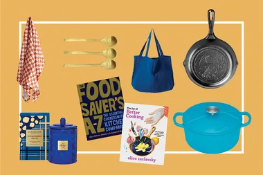 Various kitchen items on a yellow background, including books, pans, spoons, a towel, a bag, and a candle.