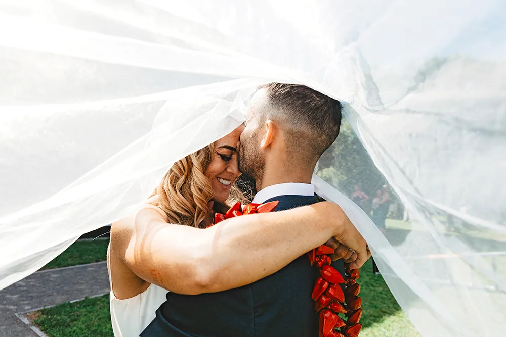 Niall and husband Tamāli'i under her wedding veil