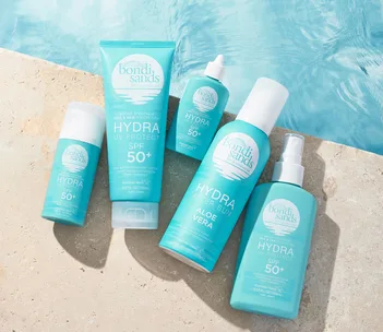 Bondi Sands Hydra UV Protect and After Sun SPF 50+ products arranged on poolside with water background.