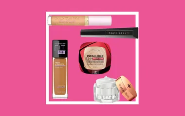 Various makeup products including concealers and foundations on a pink background.