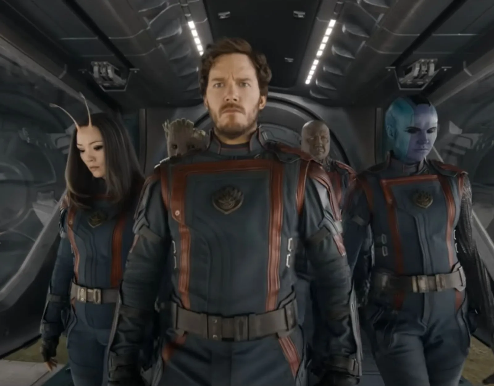 Characters from "Guardians of the Galaxy" in uniforms, walking in a spaceship corridor.