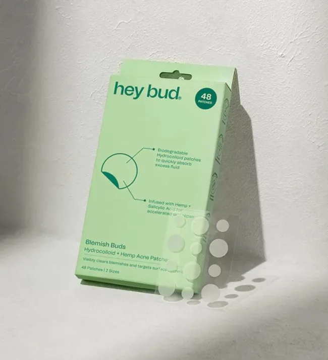 Green box of "Hey Bud" hydrocolloid blemish patches, 48 count, against a textured wall with shadow.