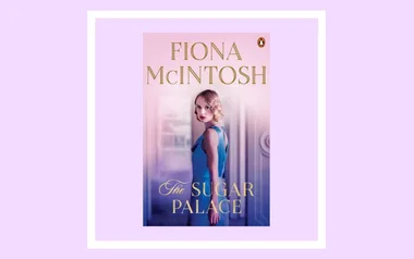 Fiona McIntosh's novel "The Sugar Palace" book cover with a woman in a blue dress, set against a soft pink background.