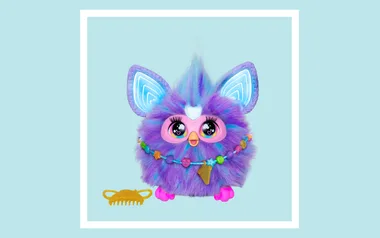 A colorful, fluffy toy creature with large eyes, bright ears, and a beaded necklace, next to a yellow comb on a light blue background.