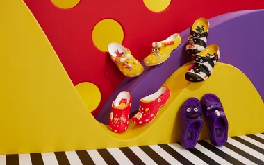 Colorful Crocs with McDonald's-themed charms on a vibrant, playful background with red, yellow, and purple.