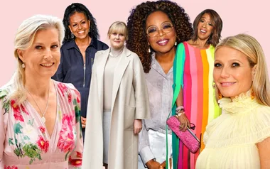 Women in colorful and formal outfits stand against a pastel background, smiling at the camera.