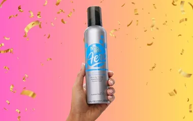 Hand holding Bondi Sands Aero tanning spray against a pink to yellow gradient background with gold confetti.