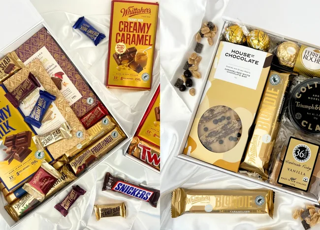Assortment of chocolates including Whittaker's, Snickers, Twix, and Ferrero Rocher in two gift boxes on white fabric.
