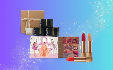 Gift set with candles, skincare boxes, illustrated card, and red and nude lipsticks on a blue gradient background.
